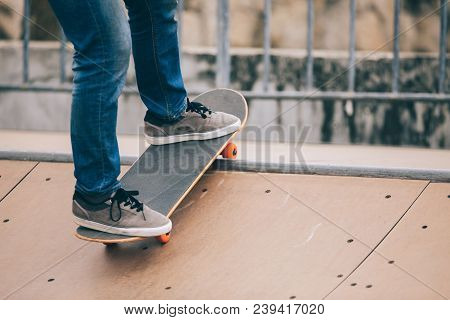 One Woman Skateboarder Sakteboarding On Skatepark Ramp