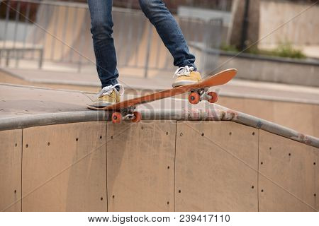 One Woman Skateboarder Sakteboarding On Skatepark Ramp