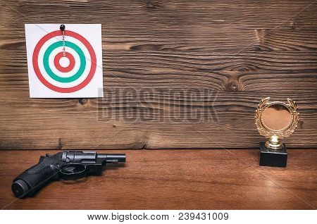 Best Shooter Award Background With Copy Space. Winner In Shooting. Gun, Paper Target And Gold Medal.