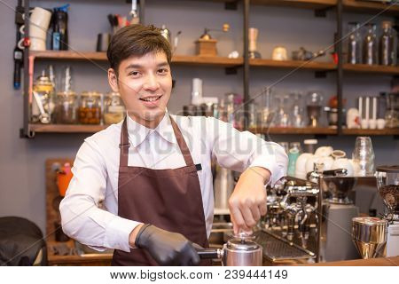 Asian Male Barista Making Coffee In Coffee Shop Counter.  Barista Male Working At Cafe. Man Working 