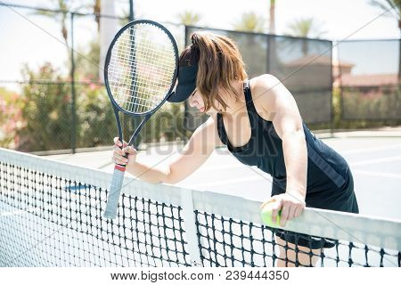 Upset Female Tennis Player Standing By The Net After Losing The Point During Tennis Match On Outdoor