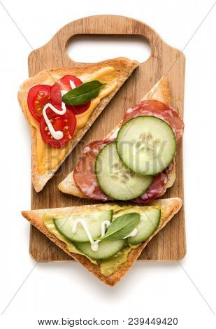 Open  faced sandwich canape or crostini on a wooden serving board  isolated on white background closeup. Top view.