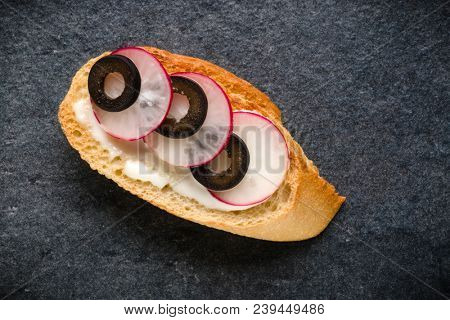 Open faced sandwich canape or crostini on dark stone background closeup. Top view. Vegetarian tartarine.