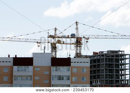 Large Construction Site Including Several Cranes Working On A Building Complex, With Clear Blue Sky 