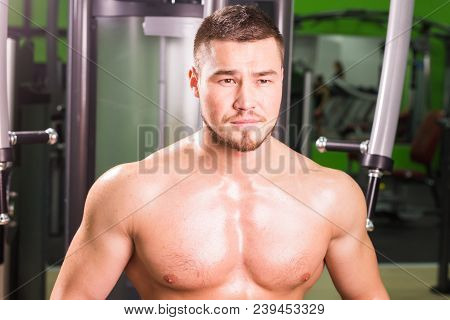 Mixed Race Man Is Working Out On Butterfly Machine In Gym.
