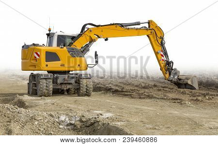 Yellow Excavator At A Loamy Construction Site, Partly Isolated In White Back