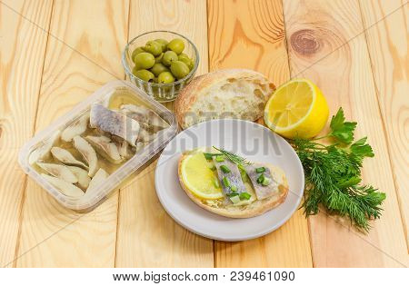 Open Sandwich With Slices Of Pickled Herring Fillet On A Saucer, Herring In Oil Marinade In Containe