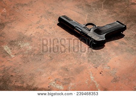 Old Russian Auto Pistol On The Concrete Red Backgroound