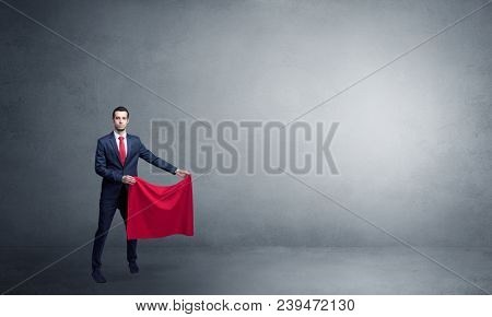 Businessman standing with red toreador cloth in his hand in an empty room