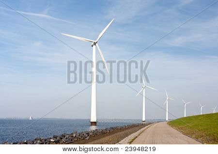 Turbine eoliche in piedi lungo la diga nel mare olandese