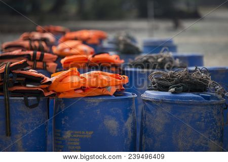 Fisherman Rope On Plastic Barrels With Orange Life Jackets In Background