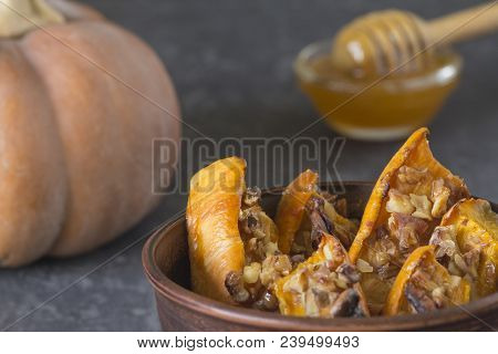Authentic View Of The Baked Sliced Pumpkin With Honey And Walnuts In A Ceramic Bowl (pial) On A Dark