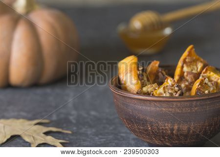 Authentic View Of The Baked Sliced Pumpkin With Honey And Walnuts In A Ceramic Bowl (pial) On A Dark
