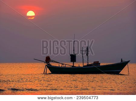 Fishing Boat Floating In The Sea. And  The Evening Light Of The Sky And The Beautiful Sea.