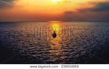 Fishing Boat Floating In The Sea. And  The Evening Light Of The Sky And The Beautiful Sea.