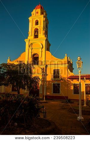 Trinidad, Cuba. The Bell Tower Of San Francisco De Asis Against The Blue Sky. Street In The Center O