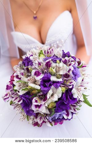 Bride In A White Wedding Dress Holding Purple Bouquet. Beautiful Bridal Decollete - Dress