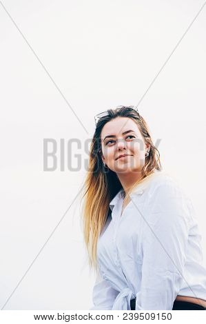 A Portrait Of A Pretty Long Haired Young Girl Wearing White Shirt And Sun Glasses, Smiling, Outdoors