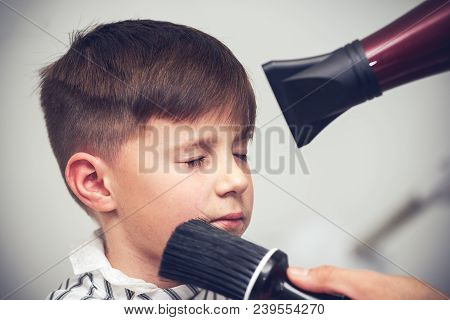 Barber Shop. Hairdresser Makes Hairstyle To A Boy.
