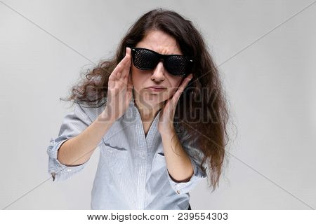 Young Girl With Glasses On A Gray Background. Portrait Of A Young Beautiful Girl. A Charming Girl In