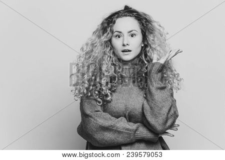 Shocked Beautiful Blue Eyed Blonde Young Woman Looks In Bewilderment At Camera, Wears Loose Red Swea