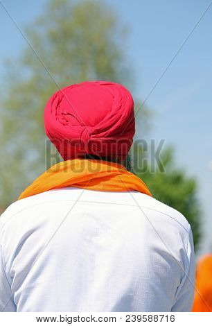 Man With Red Turban White Shirt And Orange Scarf From Behind