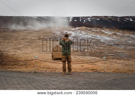 Men Walking Near Geyser. Nature And Steam Rock