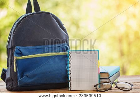 School Backpack With Books On Wooden Table And Nature Background.