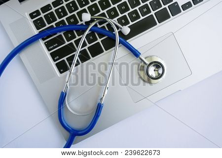 A Laptop With A Stethoscope Lying On Top Of It From Top View Perspective.