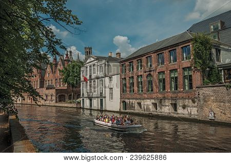 Bruges, Belgium - July 05, 2017. Boat And Brick Buildings On The Canal Edge At Bruges. With Many Can
