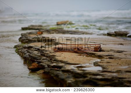 Overgrown With Algae Wooden Pallet On The Beautiful Sand Beach Near Noja, Spain , As A Symbol Of Hum