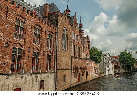 Old Brick Buildings On The Canal Edge In A Sunny Day At Bruges. With Many Canals And Old Buildings, 