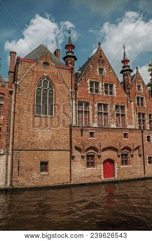 Old Brick Buildings On The Canal Edge In A Sunny Day At Bruges. With Many Canals And Old Buildings, 