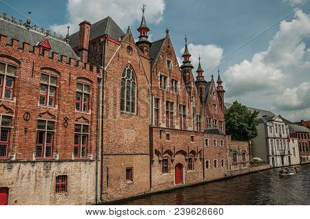 Old Brick Buildings On The Canal Edge In A Sunny Day At Bruges. With Many Canals And Old Buildings, 