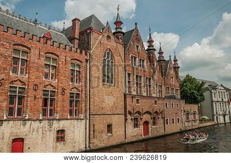 Bruges, Belgium - July 05, 2017. Boat And Brick Buildings On The Canal Edge At Bruges. With Many Can