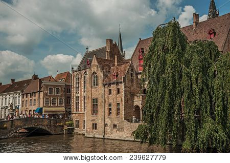 Bruges, Belgium - July 05, 2017. Bridge And Old Buildings On The Canal Edge At Bruges. With Many Can