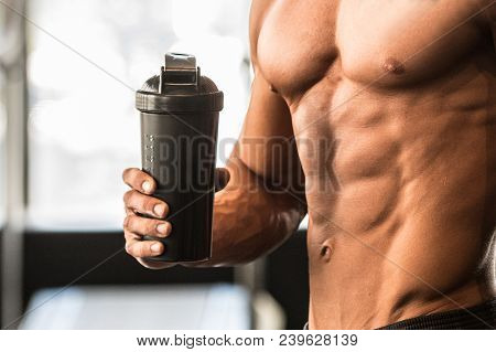 Man With Perfect Body Holds Protein Shaker In The Gym After Workout