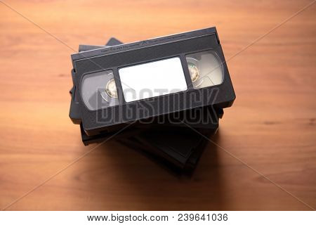 Stacked VHS vcr video cassette tape with white blank label.