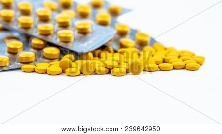 Selective Focus On Yellow Tablets Pills On Blurred Background Of Blister Pack Of Round Yellow Pills.
