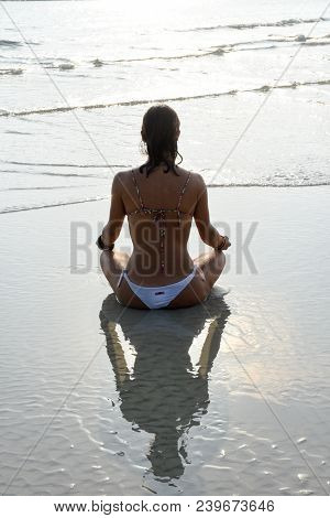Girl Who Practices Yoga On The Beach