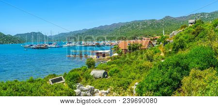 The View On Harbor Of Ucagiz Village With Tourist Yachts From The Green Hill Of Ancient Lycian Necro