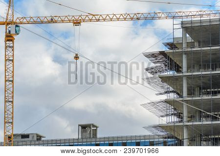 Construction Site With Crane And With Unfinished Skeleton Of A High-rise Building Made Of Reinforced