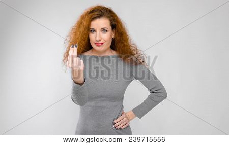 Charming Young Girl With Red Hair. A Young Girl In A Gray Sweater. Young Girl On A Gray Background.