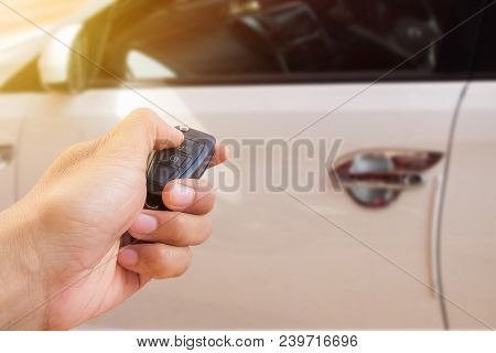 Men's Hand Presses On The Remote Control Car Alarm Systems With Sunlight