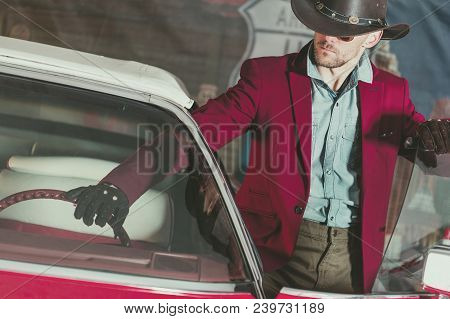 Western Wear Cowboy Driver. Caucasian Men And His Classic Vintage Car. American Transportation Theme