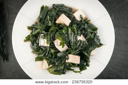Wakame Seaweed Salad On Natural Stone Background. Healthy Algae Food With Soy Sauce And Tofu