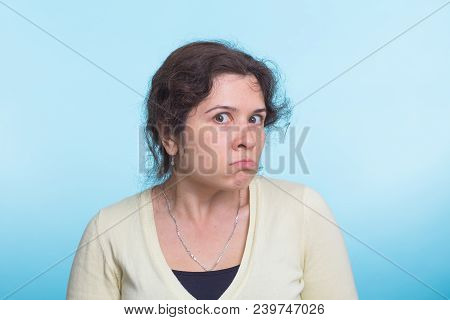 Portrait Of Young Angry Woman On Blue Background.