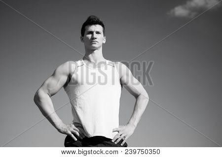 Sport And Healthy Lifestyle Concept. Man Bodybuilder Posing On Blue Sky. Fitness Model With Muscular
