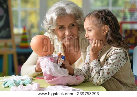 Portrait Of Grandmother And Child Play With Baby Doll