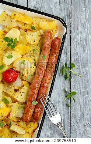 Tasy Baked Potato Slices With Fried Munich Sausages With Basil Leaves On A Baking Sheet